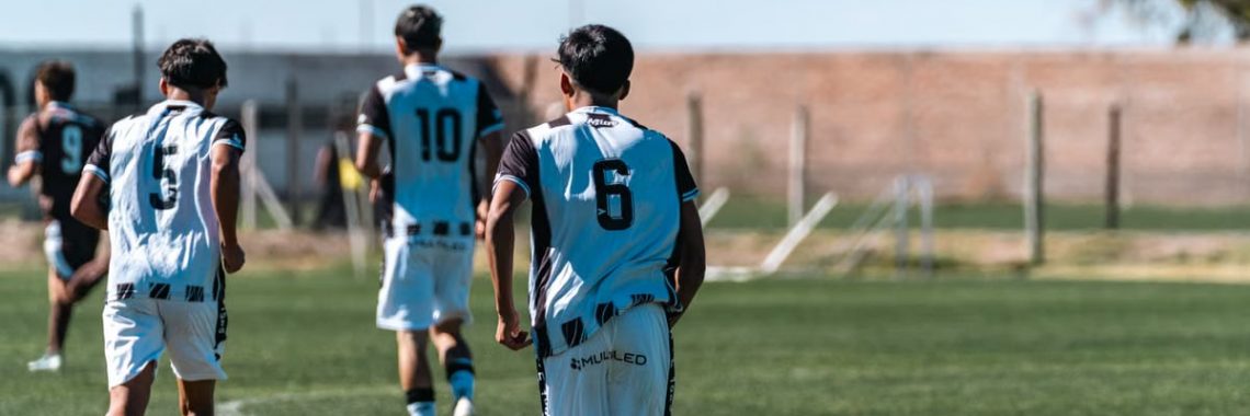 Young soccer players in jerseys during a daytime match on a grass field.